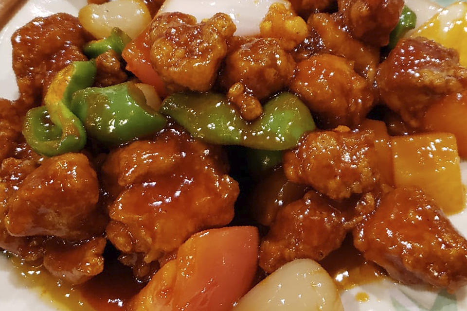 FILE - This Nov. 28, 2019, file photo shows a plate of sweet and sour pork served at a Chinese restaurant in New York City. Merriam-Webster has updated its entry on “Chinese restaurant syndrome,” a term many Asian Americans saw as antiquated and even racist. The phrase was previously defined as a legitimate illness brought on by food seasoned with monosodium glutamate but “especially Chinese food.” (AP Photo/Wong Maye-E, File)