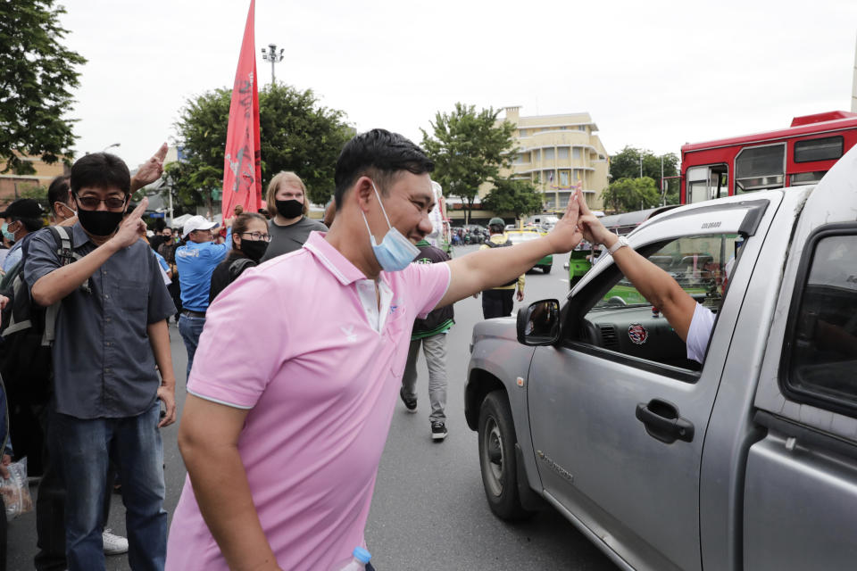 Anti-government protesters raise three-finger salutes, a symbol of resistance, during a protest near Democracy Monument in Bangkok, Thailand, Wednesday, Oct. 14, 2020. Thai activists hope to keep up the momentum in their campaign for democratic change with a third major rally in Bangkok on Wednesday. (AP Photo/Gemunu Amarasinghe)