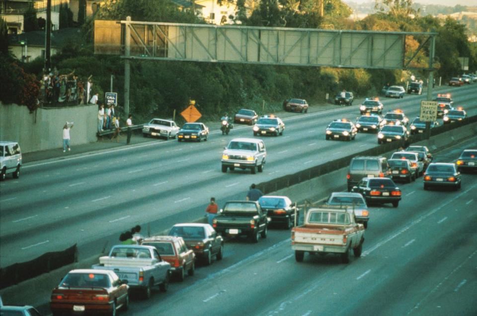 Motorists stopped their cars to watch police chase the white Ford Bronco driven by Al Cowlings with OJ Simpson aboard on the 405 Freeway in Los Angeles on June 17, 1994.