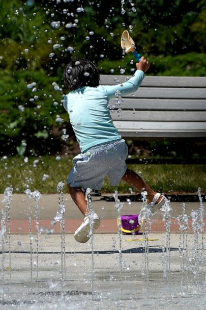 PHOTO: A child cools off during hot weather as he plays with the water fountains at Little Bear Park in Glenview, Ill., July 20, 2022.  (Nam Y. Huh/AP)