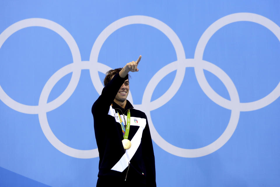 FILE - In this Augl 13, 2016 file photo, Italy's Gregorio Paltrinieri celebrates his gold during the medal ceremony for the men's 1500-meter freestyle final during the swimming competitions at the 2016 Summer Olympics, in Rio de Janeiro, Brazil. The International Olympic Committee is slated in January 2021 to consider imposing a humiliating probation on Italy’s team for the Tokyo Games due to a two-year domestic dispute that it says amounts to government interference. (AP Photo/Michael Sohn, file)