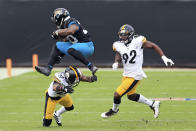 Jacksonville Jaguars running back James Robinson, left, leaps over Pittsburgh Steelers cornerback Steven Nelson (22) as linebacker Olasunkanmi Adeniyi (92) comes in to help during the first half of an NFL football game, Sunday, Nov. 22, 2020, in Jacksonville, Fla. (AP Photo/Matt Stamey)