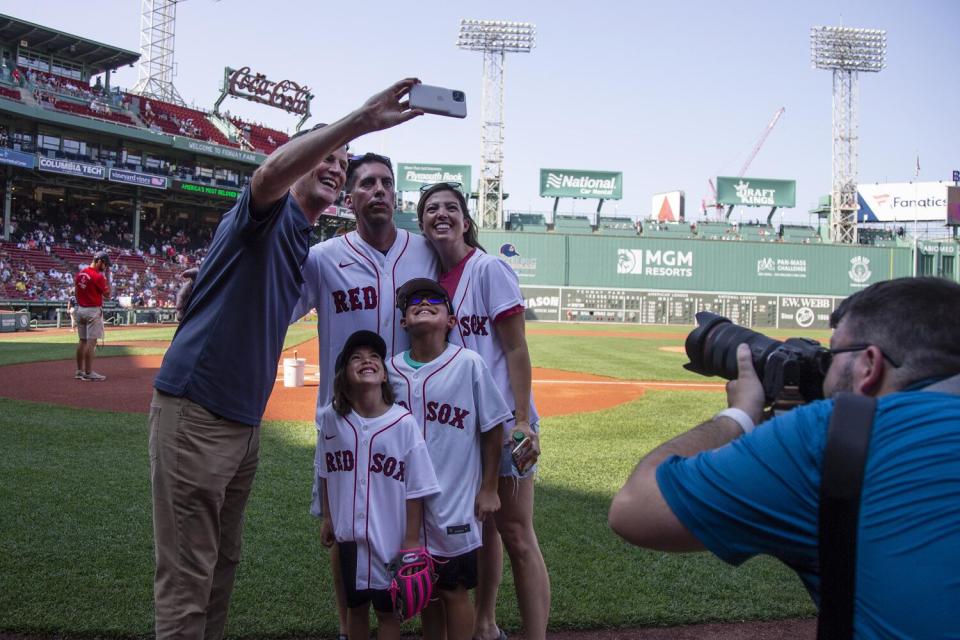 Sam Kennedy, left, takes a group selfie with Chris Snow, Snow's wife and their two children