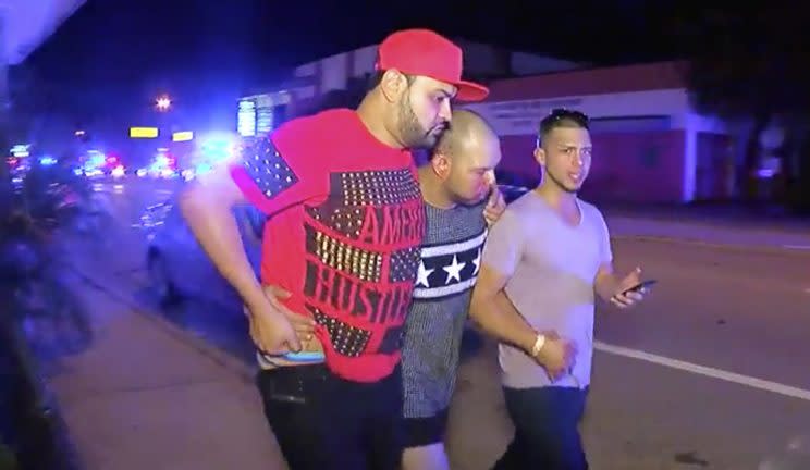 An injured man is escorted out of the Pulse nightclub after a shooting rampage early Sunday morning in Orlando. (Photo: Steven Fernandez/AP)