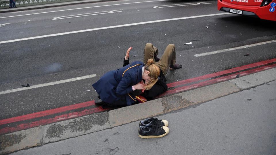 A woman holds a seriously injured man on Westminster Bridge. Source: Reuters