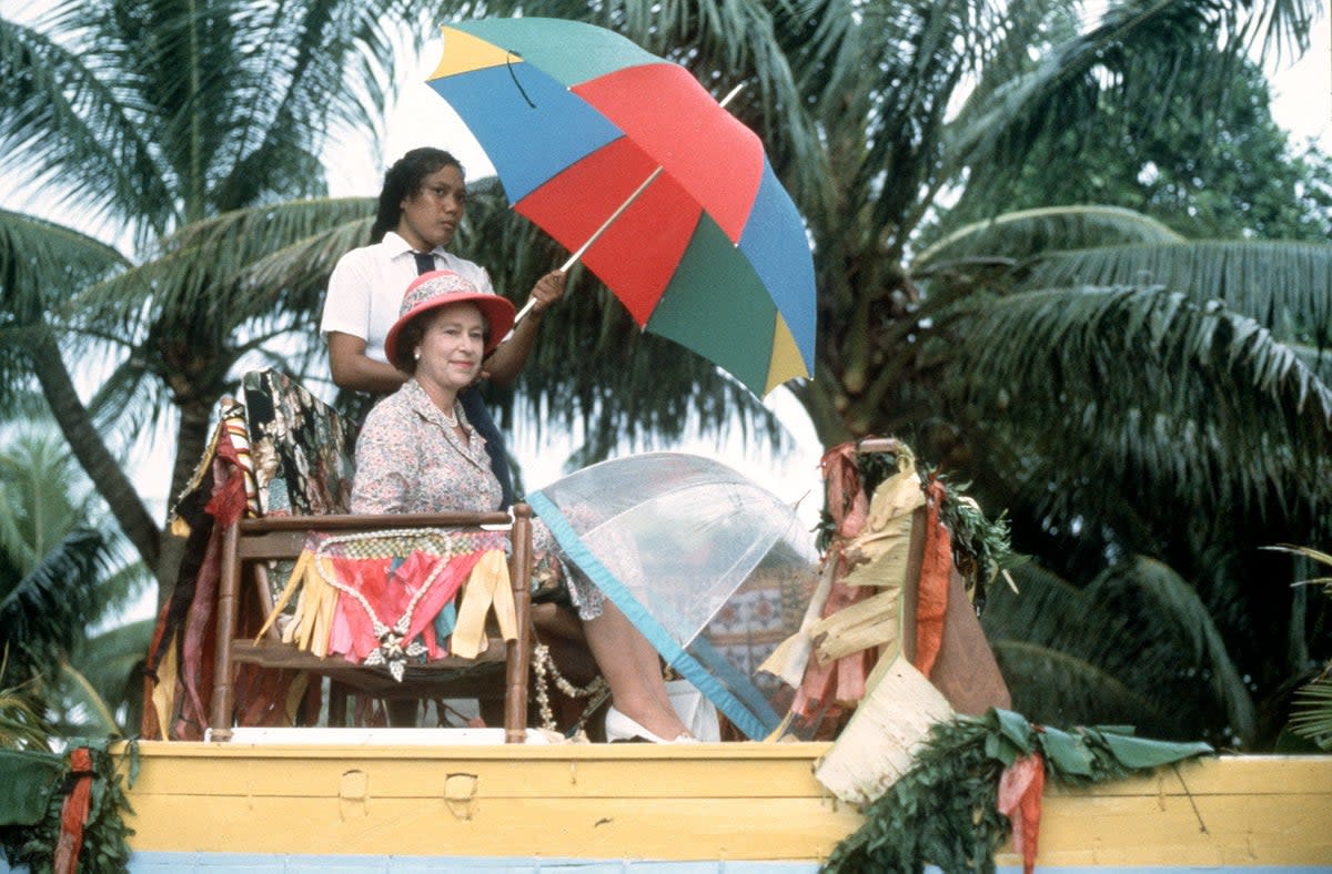 The Queen is carried shoulder high in a canoe to the shore of Tuvalu at the end of her visit to the South Sea Islands in 1982 (PA) (PA Archive)