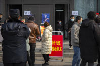 People wearing face masks to protect against the spread of the coronavirus walk out of a site for mass COVID-19 testing in a central district of Beijing, Friday, Jan. 22, 2021. Beijing has ordered fresh rounds of coronavirus testing for about 2 million people in the downtown area following new cases in the Chinese capital. (AP Photo/Mark Schiefelbein)