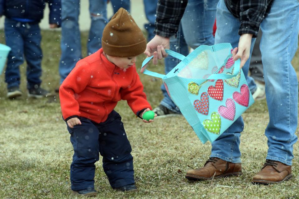 Jaxson Lownsberry, 2, drops an egg into a bag during the Egg Scramble on Saturday, April 8, at the Emmet County Fairgrounds in Petoskey.