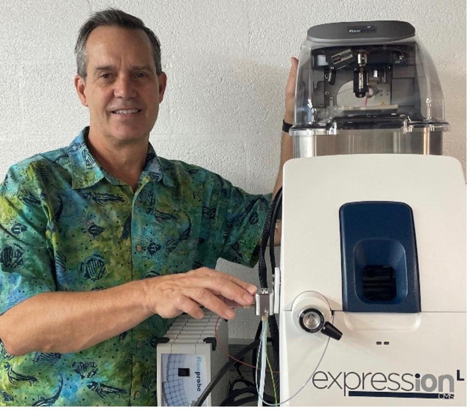 Gary Van Berkel standing next to a Van Berkel Ventures, LLC mass spectrometer fitted with both an Advion Touch Express Open Port Sampling Interface (right hand, front) and a Prosolia flowprobe (left hand, top back). Both commercial products are based on his inventions.