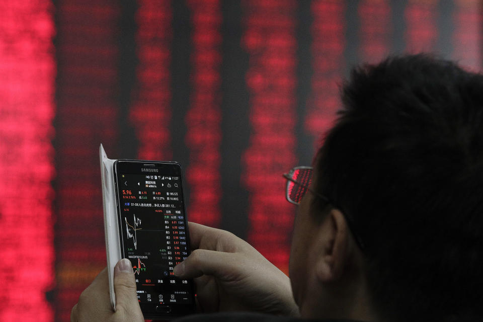 A man checks stock prices through his smartphone at a brokerage house in Beijing, Wednesday, Jan. 9, 2019. Shares extended gains in Asia on hopes for progress in resolving the tariffs battle between the U.S. and China as talks appeared to have been extended in Beijing. (AP Photo/Andy Wong)