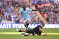 Manchester City's Yaya Toure and Wigan Athletic's Paul Scharner (right) battle for the ball