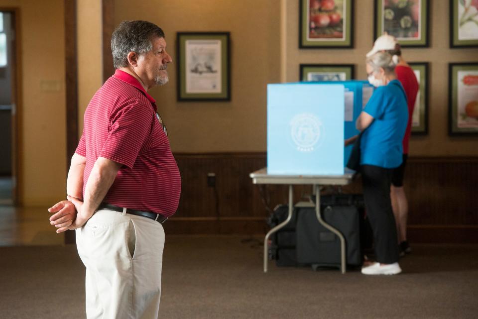 Poll manager John Leffler looks on as voters in Precinct 1-01, First Presbyterian Church cast ballots in the May 24 primary.