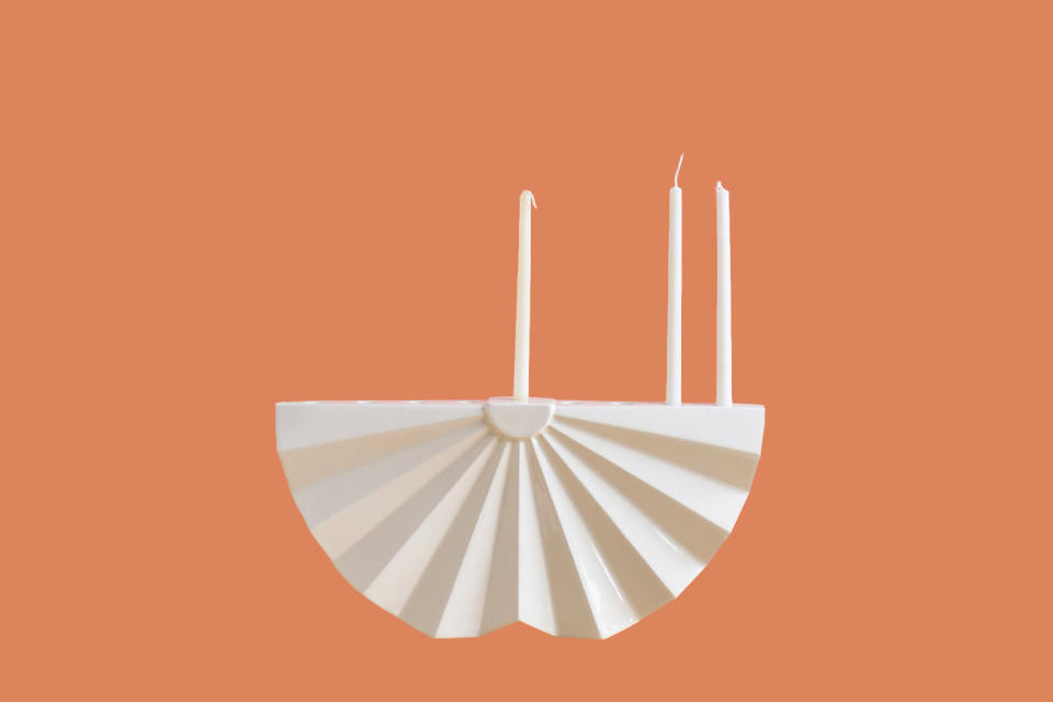 <p>Female design duo Anat Stein and Hadas Kruk offer a collection of religious artifacts and home décor that celebrates Jewish tradition through modern design. This white ceramic menorah in a fanned shape is one of the many handmade artifacts from their workshop in Tel Aviv, Israel.</p><p><em>Studio Armadillo White Ceramic Origami-Style Menorah, $189, </em><a href="http://www.awin1.com/cread.php?awinaffid=272513&awinmid=6220&clickref=MMSLHOLModernMenorahsCBiggsOct19&platform=dl&p=%5B%5Bhttps%3A%2F%2Fwww.etsy.com%2Flisting%2F161590453%2Fhanukkah-menorah-modern-geometric%5D%5D" rel="nofollow noopener" target="_blank" data-ylk="slk:etsy.com;elm:context_link;itc:0;sec:content-canvas" class="link "><em>etsy.com</em></a><em>.</em></p>