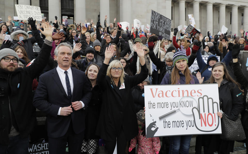 FILE - Robert F. Kennedy, Jr., left, stands with protesters at the Capitol in Olympia, Wash., on Feb. 8, 2019, where they opposed a bill to tighten measles, mumps and rubella vaccine requirements for school-aged children. He carved out a career as a bestselling author and top environmental lawyer fighting for important public health priorities such as clean water. His work as a leading voice in that movement likely would have been his legacy, but more than 15 years ago, he became fixated on a belief that vaccines are not safe, despite overwhelming scientific consensus that they are. (AP Photo/Ted S. Warren, File)