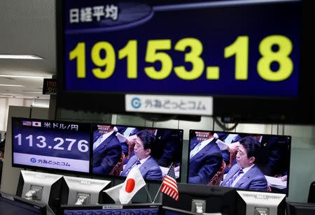 A TV monitor showing Japanese Prime Minister Shinzo Abe is seen next to monitors showing the Japanese yen's exchange rate against the U.S. dollar (L) and Nikkei average at a foreign exchange trading company in Tokyo, Japan, February 1, 2017. REUTERS/Kim Kyung-Hoon