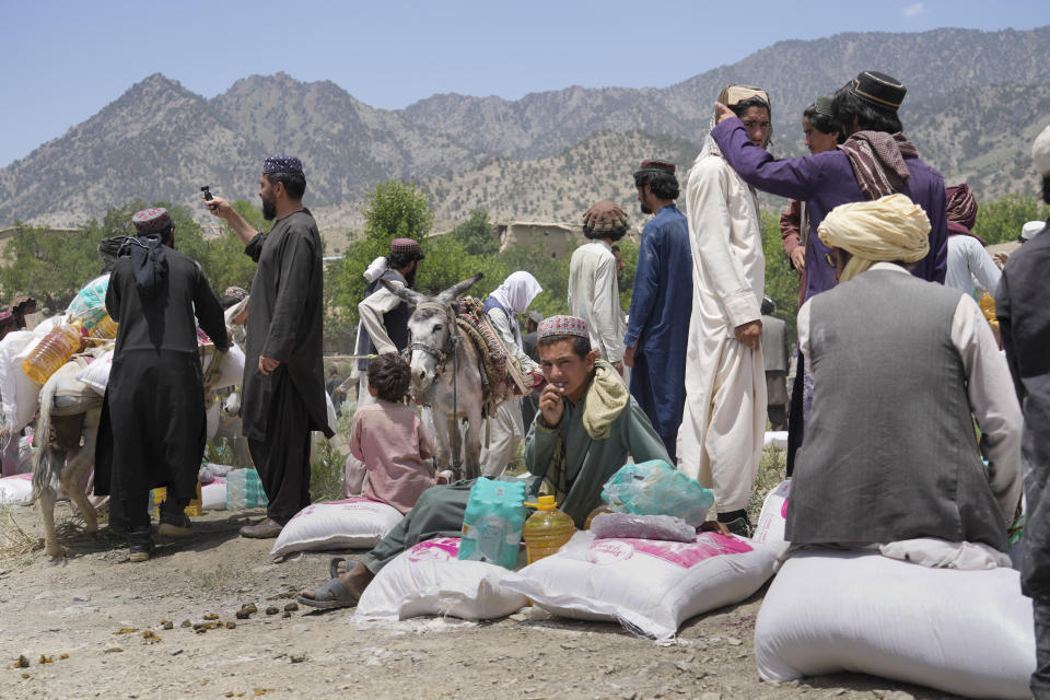 Afghans receive aid at a camp after an earthquake in Gayan district in Paktika province, Afghanistan, Sunday, June 26, 2022. A powerful earthquake struck a rugged, mountainous region of eastern Afghanistan early Wednesday, flattening stone and mud-brick homes in the country's deadliest quake in two decades, the state-run news agency reported. (AP Photo/Ebrahim Nooroozi)