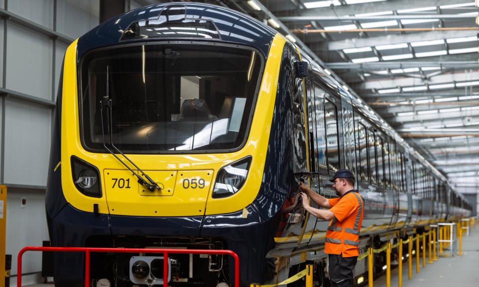 <span>Mick Waldram works on a train at Alstom’s plant in Derby.</span><span>Photograph: Fabio De Paola/The Guardian</span>