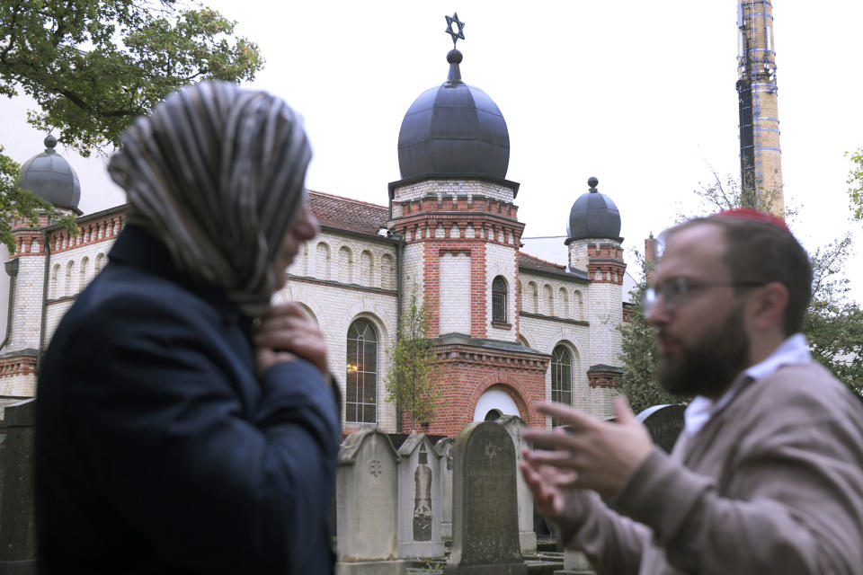 Jeremy Borovitz, right, gestures as he stays in front of a synagogue in Halle, Germany, Thursday, Oct. 10, 2019. A heavily armed assailant ranting about Jews tried to force his way into a synagogue in Germany on Yom Kippur, Judaism's holiest day, then shot two people to death nearby in an attack Wednesday that was livestreamed on a popular gaming site. (AP Photo/Jens Meyer)