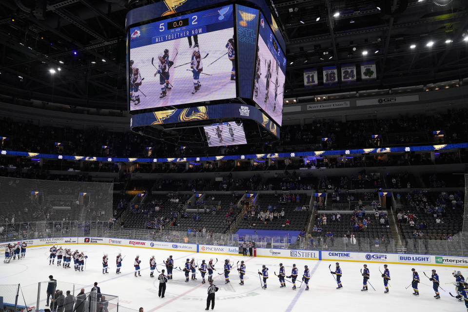 Members of the Colorado Avalanche and St. Louis Blues shake hands following Game 4 of an NHL hockey Stanley Cup first-round playoff series Sunday, May 23, 2021, in St. Louis. Colorado won the game 5-2 to take the series 4-0. (AP Photo/Jeff Roberson)