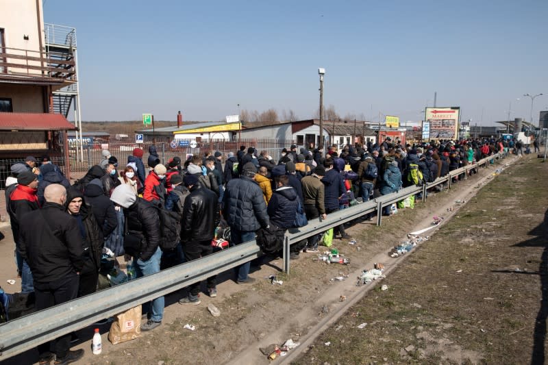 People queue to cross to Ukraine at the border crossing in Dorohusk