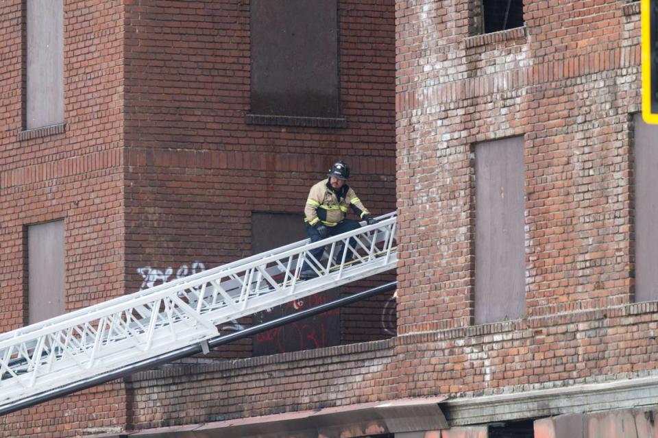 A firefighter works on a ladder at the burnt out Hotel Marysville last month that caught fire on June 15.