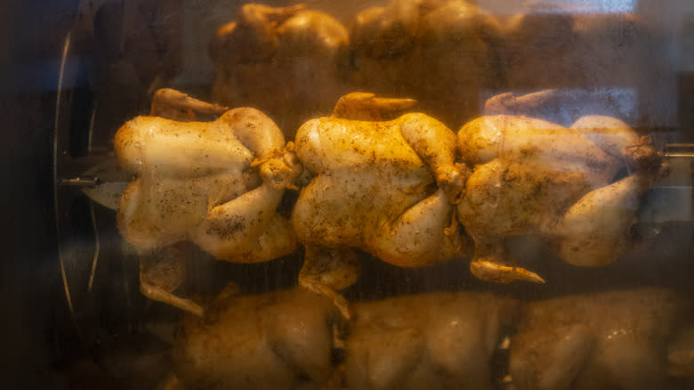 rotisserie chickens cooking in oven