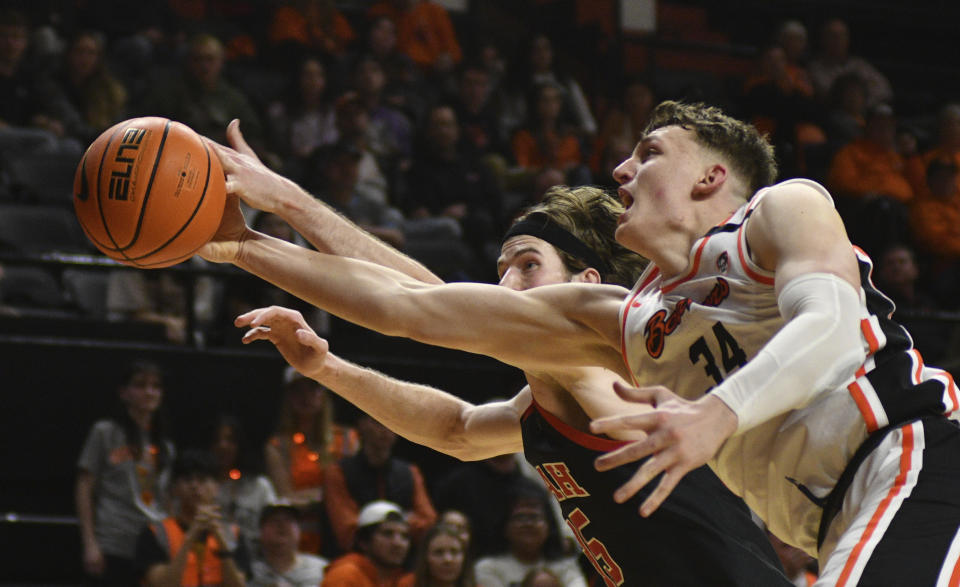 Oregon State forward Tyler Bilodeau (34) and Utah center Branden Carlson reach for the ball during the second half of an NCAA college basketball game Thursday, March 7, 2024, in Corvallis, Ore. Oregon State won 92-85. (AP Photo/Mark Ylen)