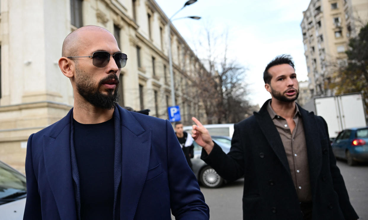 Andrew Tate (L) and Tristan Tate (R) walk from the Bucharest's Court of Appeal after a hearing about their demand to be allowed to leave Romania as their mother allegedly suffered a heart attack, in Bucharest, on December 22, 2023. Brothers Andrew and Tristan Tate, on trial for accusations of human trafficking and rape, remain under judicial control and cannot leave Romania, the Bucharest Court of Appeal decided on Friday. The court's decision is final. (Photo by Daniel MIHAILESCU / AFP) (Photo by DANIEL MIHAILESCU/AFP via Getty Images)