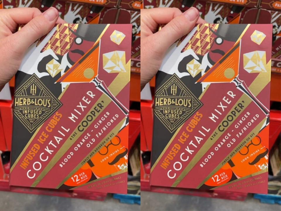 Hand holding  colorful red and orange package of old fashioned infused ice cubes at costco