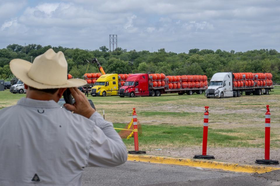 A person surveys buoy barriers before they are installed in the Rio Grande on July 7, 2023. <a href="https://www.gettyimages.com/detail/news-photo/person-speaks-on-the-phone-while-surveying-the-preparation-news-photo/1523062022?adppopup=true" rel="nofollow noopener" target="_blank" data-ylk="slk:Brandon Bell/Getty Images;elm:context_link;itc:0;sec:content-canvas" class="link ">Brandon Bell/Getty Images</a>