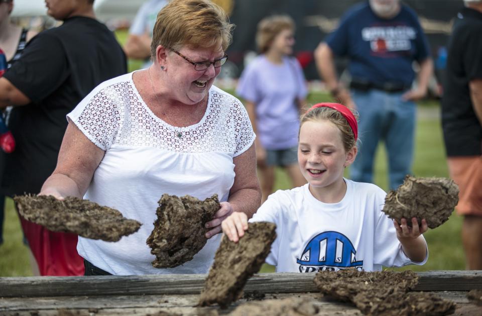 Glenwood Elementary School teacher Mary Bennett, left, helps out her former student, Lyla Franke, right, in picking the perfect cow chip to use in the Illinois Championship Cow Chip Throw during the Chatham Jaycees Sweet Corn Festival at the Chatham Community Park, Saturday, July 16, 2016, in Chatham, Ill. Justin L. Fowler/The State Journal-Register