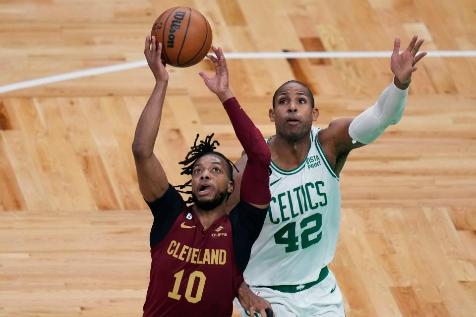 Cleveland Cavaliers guard Darius Garland (10) reaches for the ball next to Boston Celtics center Al Horford (42) during the first half of an NBA basketball game Wednesday, March 1, 2023, in Boston. (AP Photo/Charles Krupa)