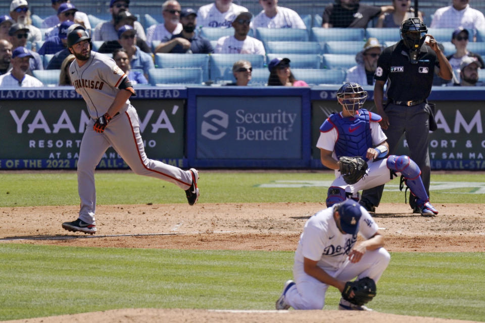 San Francisco Giants' Darin Ruf, left, heads to first after hitting a two-run home run as Los Angeles Dodgers starting pitcher Clayton Kershaw, second from left, reacts and catcher Austin Barnes, second from right, watches along with home plate umpire Malachi Moore during the fifth inning of a baseball game Sunday, July 24, 2022, in Los Angeles. (AP Photo/Mark J. Terrill)