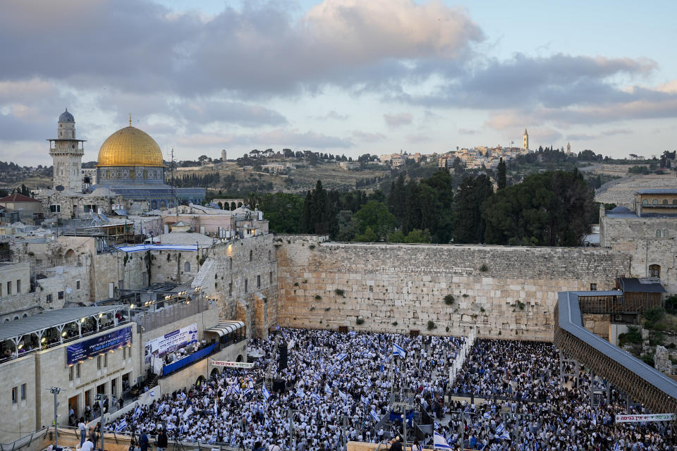 Thousands of Israelis dance and wave national flags during a march marking Jerusalem Day, an Israeli holiday celebrating the capture of east Jerusalem in the 1967 Mideast war, at the Western Wall, the holiest site where Jews can pray in the Old City of JerusalemThursday, May 18, 2023. (AP Photo/Ohad Zwigenberg)