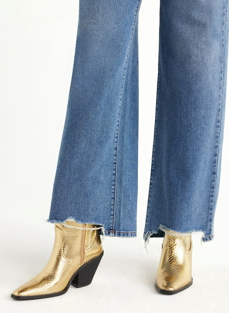 model wearing gold western-style booties with wide leg jeans