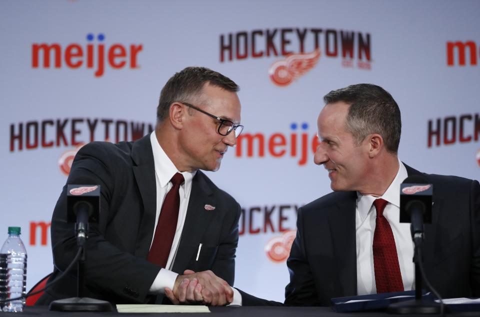 Steve Yzerman, left, shakes hands with Christopher Ilitch, president and CEO of Ilitch Holdings, Inc. after being introduced as the new executive vice president and general manager of the Detroit Red Wings NHL hockey club, Friday, April 19, 2019, in Detroit. Yzerman returns to Detroit where he was part of three Stanley Cup championship teams and a captain. (AP Photo/Carlos Osorio)