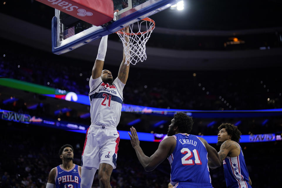 Washington Wizards' Daniel Gafford, center, goes up for a dunk against Philadelphia 76ers' Tobias Harris, from left, Joel Embiid and Kelly Oubre Jr. during the first half of an NBA basketball game, Monday, Nov. 6, 2023, in Philadelphia. (AP Photo/Matt Slocum)