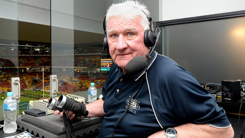 Veteran caller Ray Warren is pictured here sitting in an NRL commentary box. 