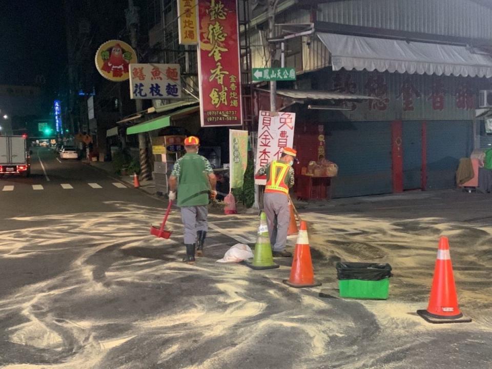 炸雞店廢油流到路面，高市環保局接獲通報，立即以木屑吸附路面油漬，並用洗衣粉清洗。（圖：鳳山分局提供）