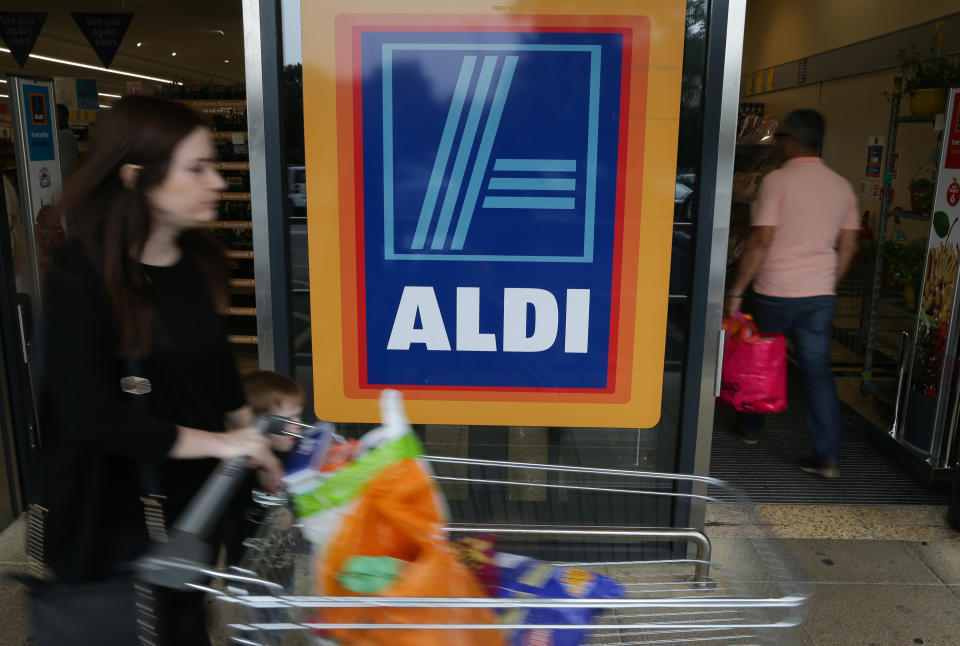 A woman pushes a shoping trolley past an Aldi logo as she leaves one of the company's supermarket stores in London on September 26, 2016. Aldi UK announced on Monday that it will invest £300 million ($389 million, 346 million euros) to revamp its stores over the next three years. Aldi and its German rival Lidl have boomed in Britain, grabbing market share from traditional supermarkets Asda, Morrison, Sainsbury's and Tesco, as customers tightened their belts to save cash. / AFP / Daniel Leal-Olivas        (Photo credit should read DANIEL LEAL-OLIVAS/AFP/Getty Images)