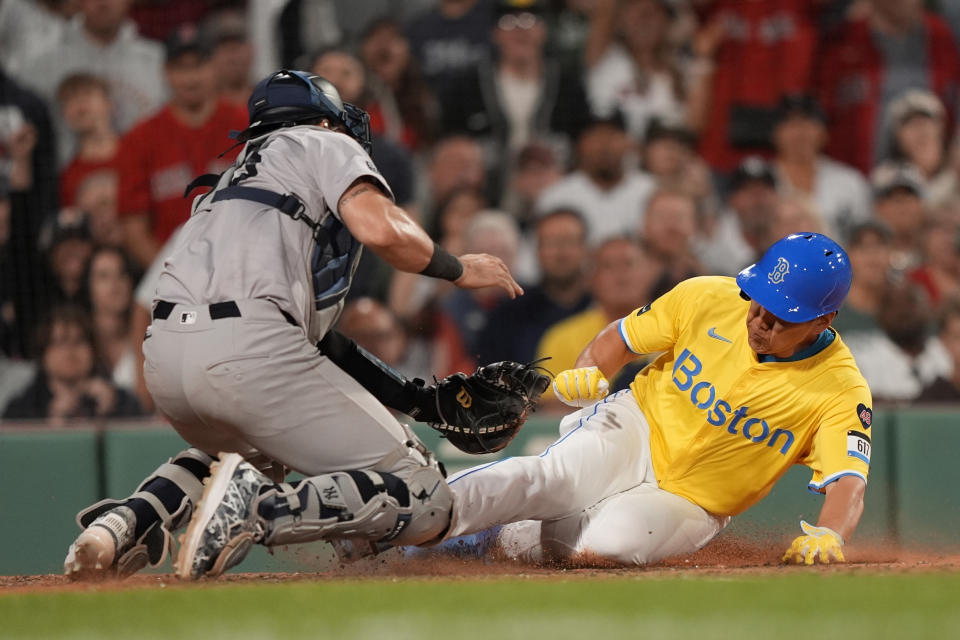 Boston Red Sox's Masataka Yoshida slides in safely ahead of the tag by New York Yankees catcher Austin Wells during the seventh inning of a baseball game against the New York Yankees, Saturday, June 15, 2024, in Boston. (AP Photo/Robert F. Bukaty)