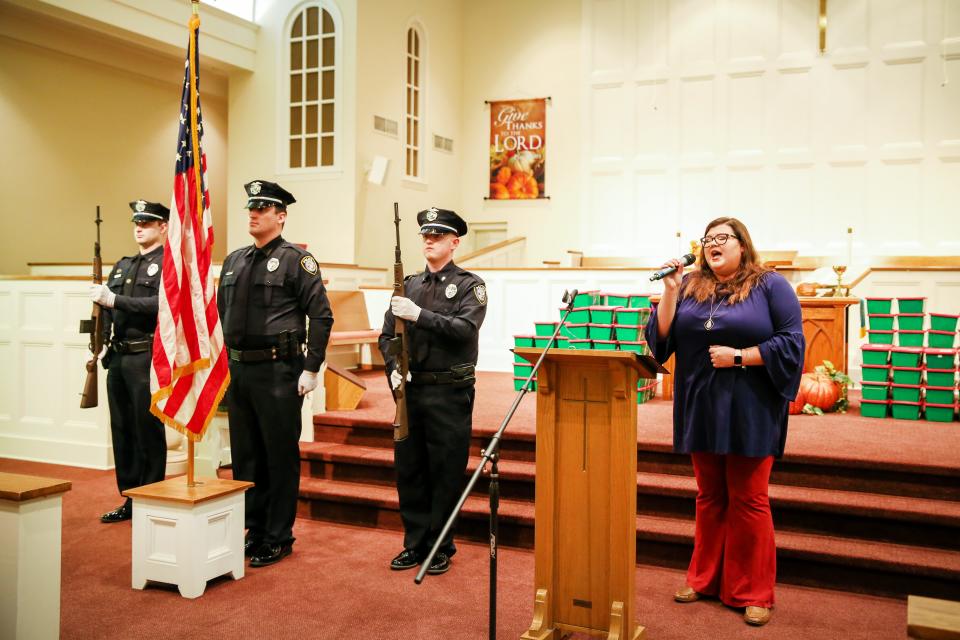 The color guard from the Jackson Police Department salute the flag, including (left) Shane Crabtree, James Cupples and Gage Schaffer as Katie McGill sings the National Anthem. The Jackson Exchange Club held its 15th annual Flags of Freedom fundraiser for the Carl Perkins Center for the Prevention of Child Abuse. The event was held at the First Cumberland Presbyterian Church in Jackson, TN November 15, 2022.