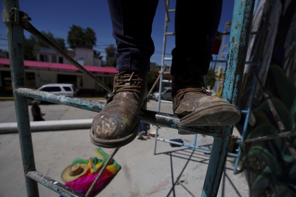 Mexican artist Yanet Calderon balances on scaffolding while painting a mural in San Salvador, Mexico, Saturday, July 30, 2022. The mural in progress is on three walls of a municipal building in San Salvador, a small town of about 29,000 people north of Mexico City in Hidalgo state. (AP Photo/Fernando Llano)