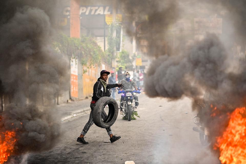 A protester burns tires during a demonstration calling for the resignation of Prime Minister Ariel Henry in Port-au-Prince on Feb. 7.