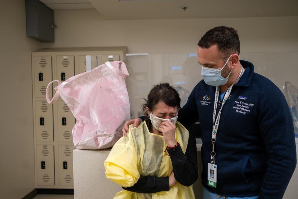 Elena Padilla, left, begins to cry as she speaks with Dr. Jason Prasso, right, inside the ICU at MLK Community Hospital.