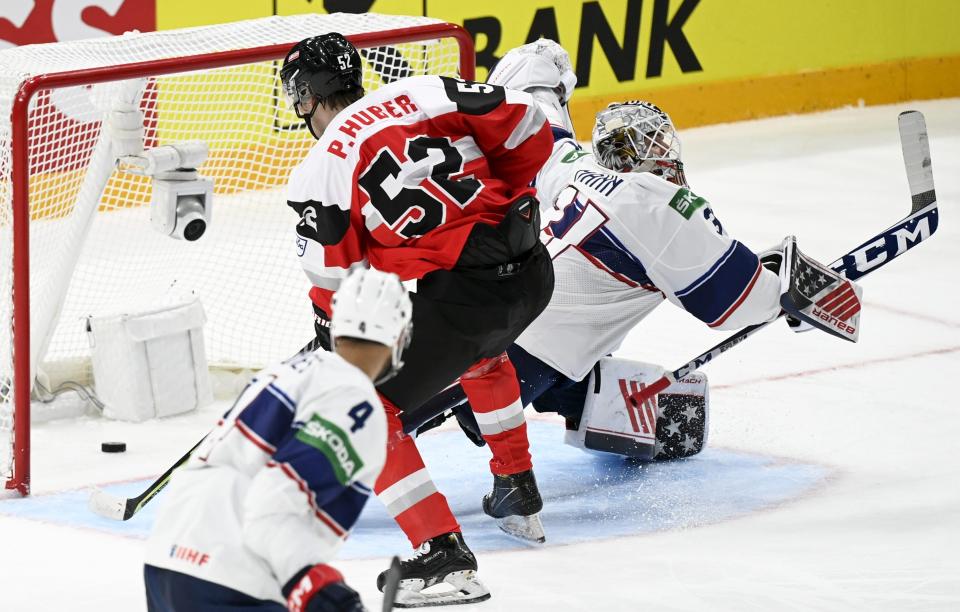 Paul Huber of Austria, center, scores a goal during the 2022 IIHF Ice Hockey World Championships preliminary round group B match between Austria and USA in Tampere, Finland, Sunday May 15, 2022. (Vesa Moilanen/Lehtikuva via AP)