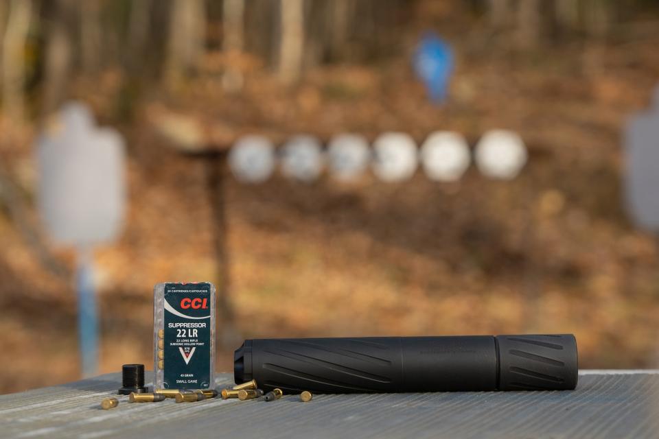 How to buy a suppressor: suppressor on a table with ammunition.