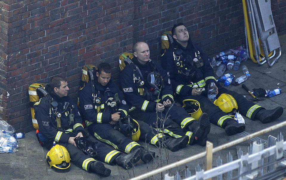 <p>Firefighters rest as they take a break in battling a massive fire that raged in a high-rise apartment building in London, Wednesday, June 14, 2017. (Photo: Matt Dunham/AP) </p>
