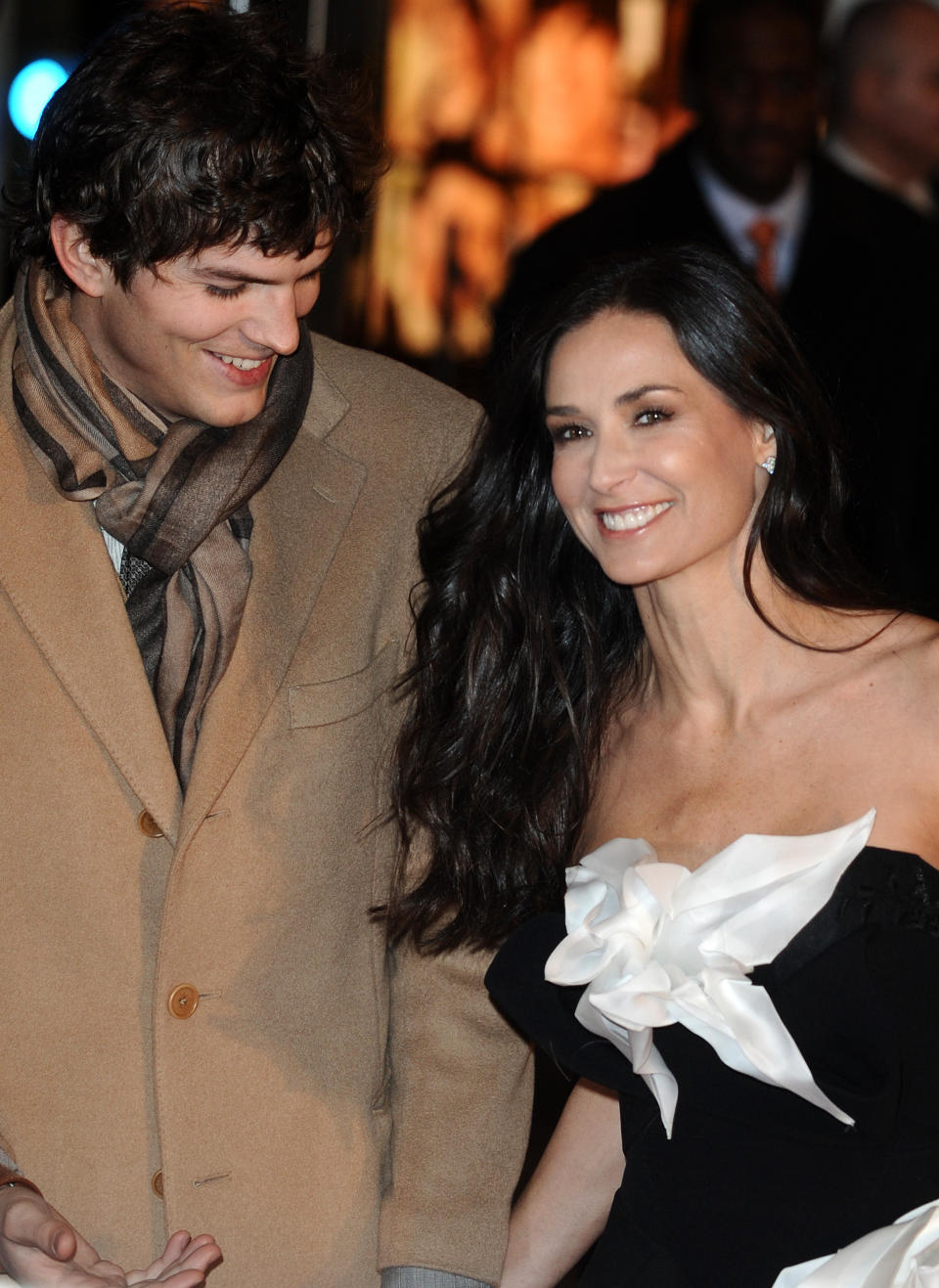 Ashton Kutcher smiles down at Demi Moore as they embrace