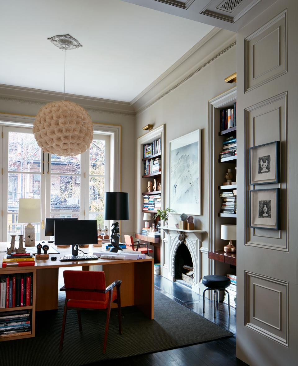 This large space, painted in Benjamin Moore Ashen Tan, was immediately transformed into Otero's home office for the interior design studio and is retained as a place to draw, sketch, and prepare his ceramic works. The pendant light is made up of dried poppy flowers and was purchased when he lived in Hong Kong. The 1950s rosewood chairs were reupholstered in red-orange linen from Gaston y Daniela at Kravet.